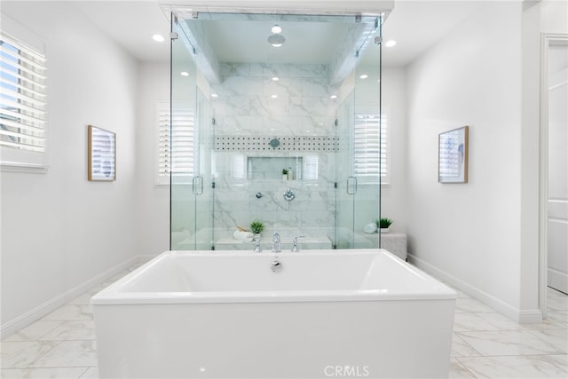 full bath featuring marble finish floor, a soaking tub, a shower stall, and baseboards