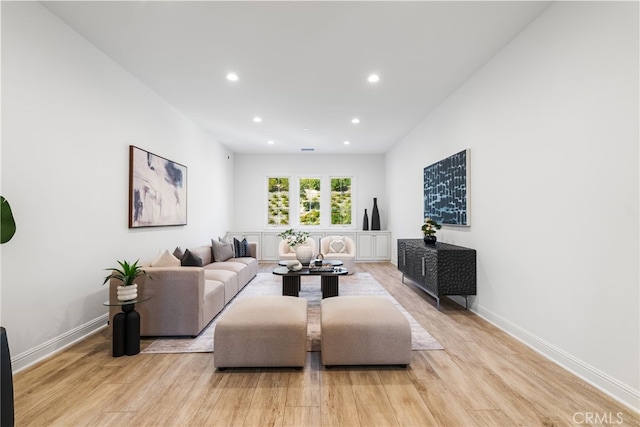 living room with light wood-type flooring, baseboards, and recessed lighting