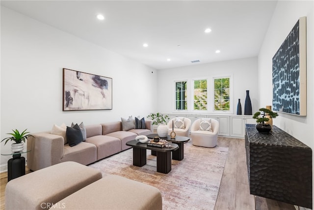 living area with light wood-type flooring, visible vents, and recessed lighting