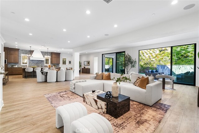 living room featuring light hardwood / wood-style flooring and an inviting chandelier