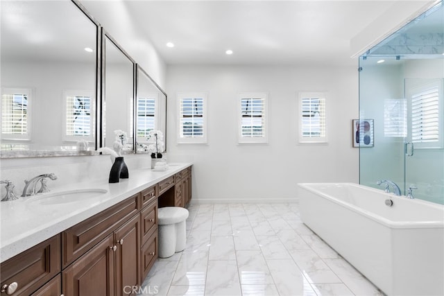 full bathroom with recessed lighting, a sink, a freestanding bath, marble finish floor, and double vanity