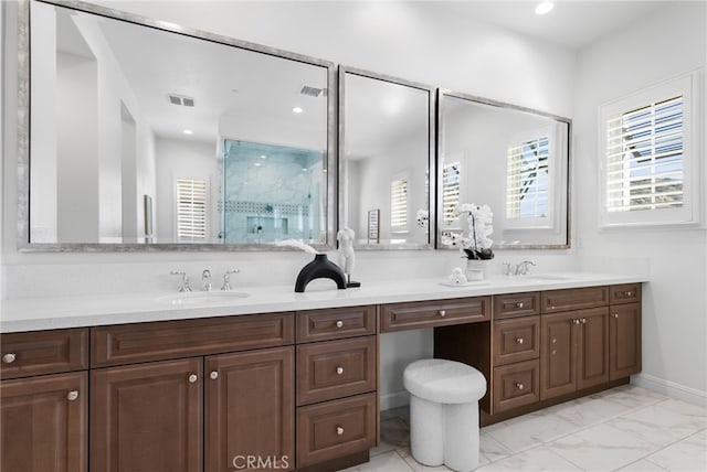 bathroom featuring a sink, a shower stall, and double vanity