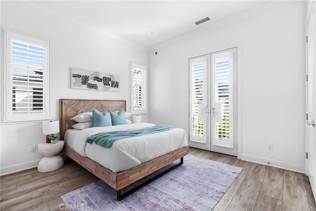 bedroom featuring access to exterior, multiple windows, visible vents, and crown molding