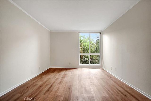 spare room featuring light hardwood / wood-style floors and crown molding