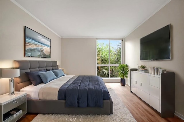 bedroom featuring a wall of windows, ornamental molding, and light hardwood / wood-style flooring