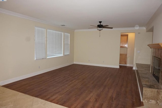 unfurnished living room featuring a fireplace, ceiling fan, crown molding, and dark wood-type flooring