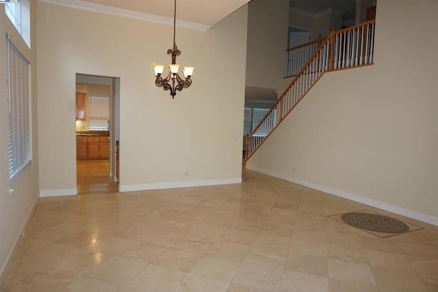 interior space featuring crown molding, a high ceiling, and an inviting chandelier