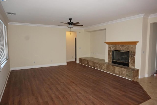 unfurnished living room featuring ceiling fan, dark hardwood / wood-style flooring, ornamental molding, and a premium fireplace