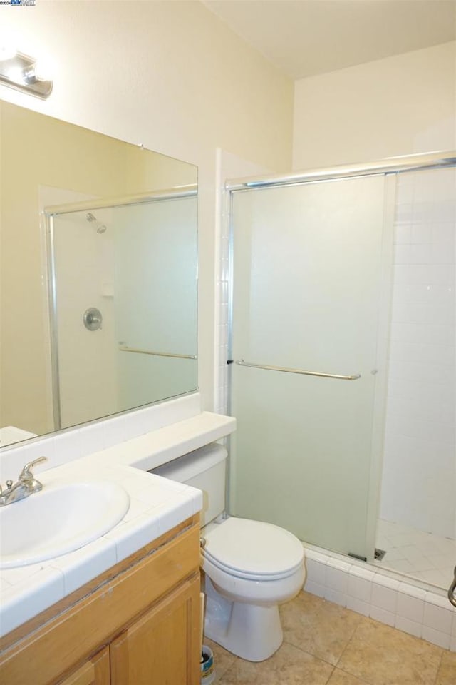 bathroom featuring tile patterned floors, vanity, and a shower with shower door