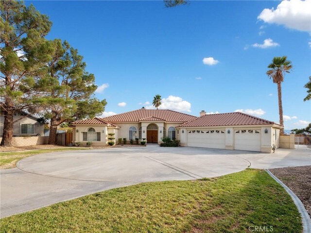 mediterranean / spanish-style home with a front yard and a garage