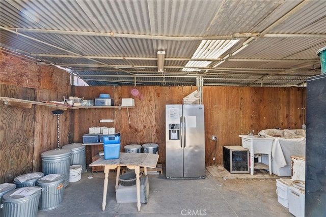 basement with stainless steel fridge and wooden walls