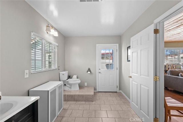 bathroom featuring vanity, toilet, and a healthy amount of sunlight