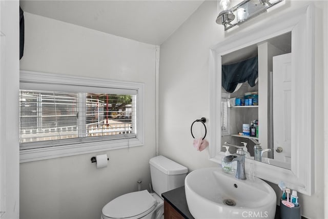 bathroom featuring vanity, lofted ceiling, and toilet