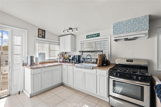 kitchen with sink, white cabinets, lofted ceiling, and stainless steel gas range