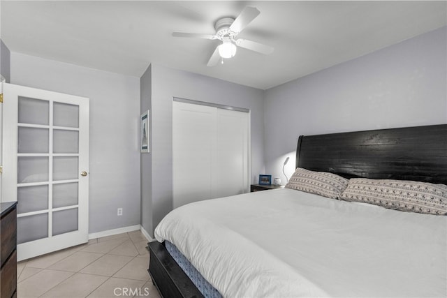 tiled bedroom featuring ceiling fan and a closet