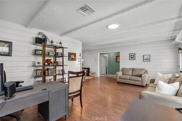 office featuring beam ceiling, wood-type flooring, and wooden walls