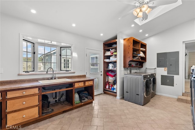 laundry room featuring electric panel, ceiling fan, sink, and washer and dryer