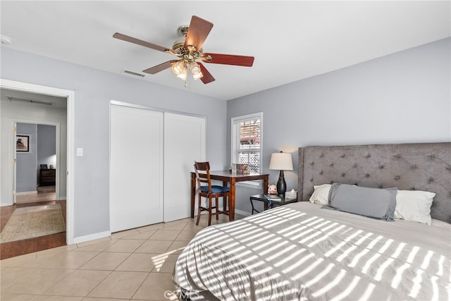 tiled bedroom with ceiling fan and a closet