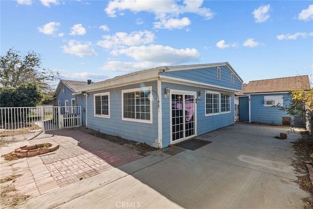 rear view of property with a patio area and an outdoor fire pit