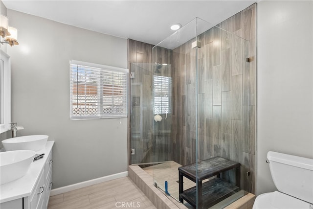 bathroom featuring wood-type flooring, vanity, toilet, and an enclosed shower