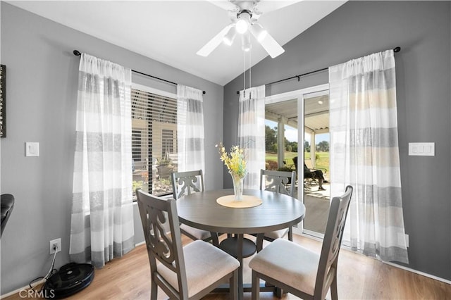 dining room featuring vaulted ceiling, ceiling fan, and light wood-type flooring