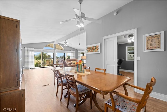 dining space featuring light hardwood / wood-style floors and vaulted ceiling with beams