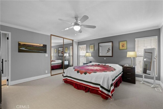 carpeted bedroom featuring ceiling fan, a closet, and crown molding