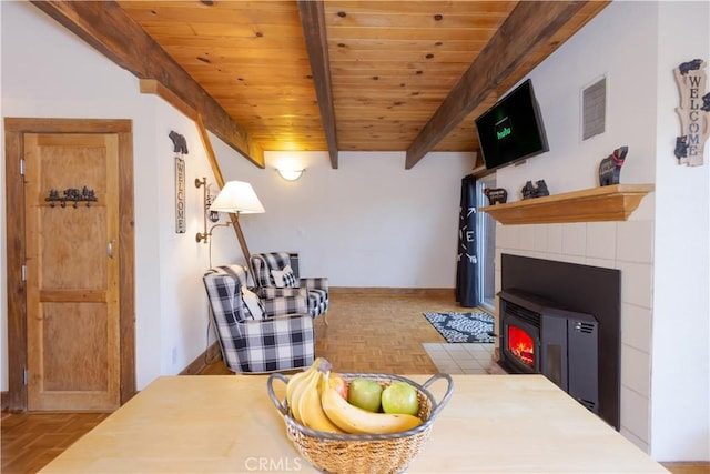 living room featuring beamed ceiling, wooden ceiling, a wood stove, and light parquet floors