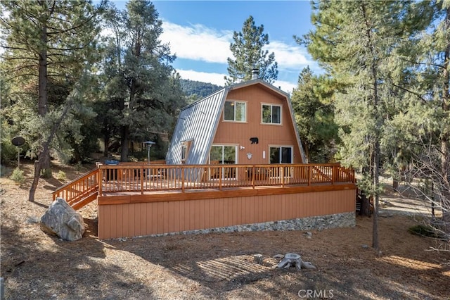 rear view of property featuring a wooden deck