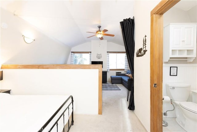 carpeted bedroom with connected bathroom and lofted ceiling