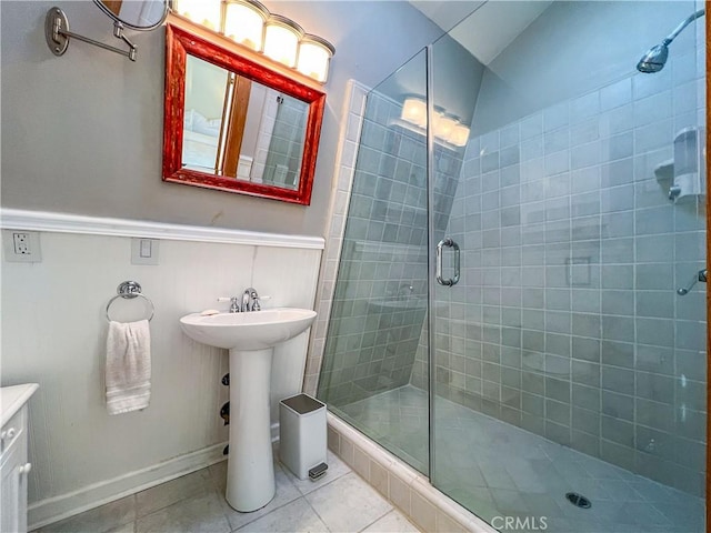 bathroom with tile patterned flooring, a shower with door, and sink