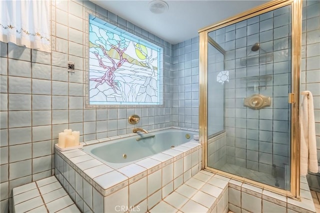 bathroom with tile patterned floors, tile walls, and independent shower and bath