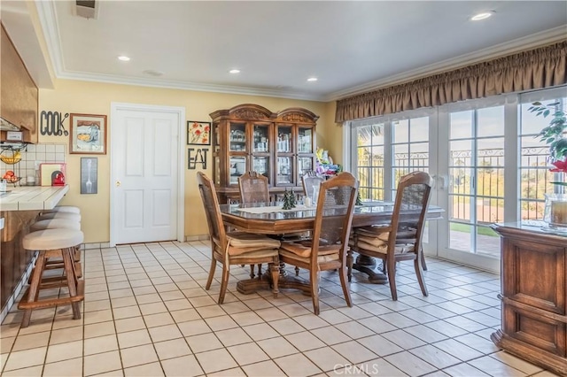 tiled dining room featuring ornamental molding