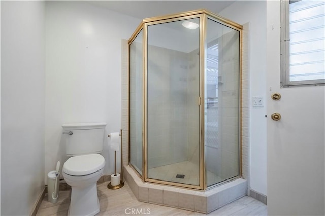 bathroom featuring toilet and a shower with door