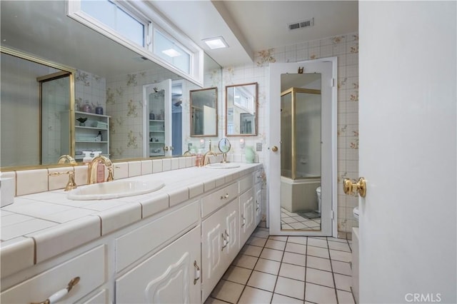 bathroom with tile patterned floors, vanity, toilet, and an enclosed shower