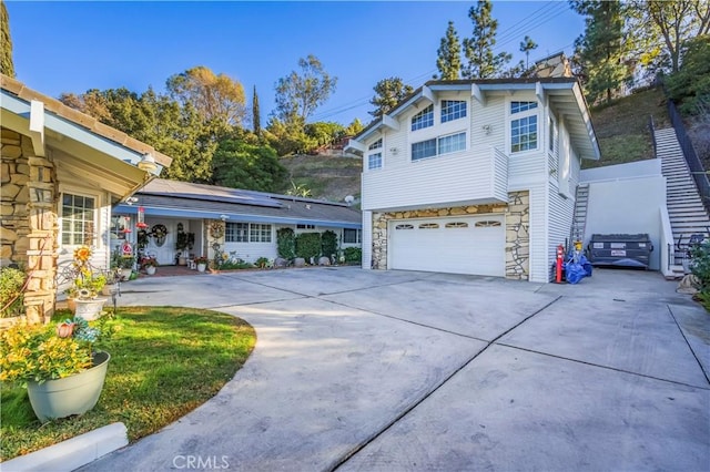 view of front of property featuring solar panels and a garage