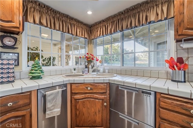 kitchen with dishwasher, tile countertops, tasteful backsplash, and sink