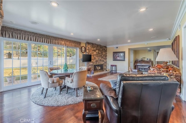 living room with dark hardwood / wood-style flooring, ornamental molding, and a fireplace