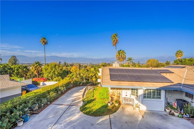 view of front of house with a mountain view and solar panels