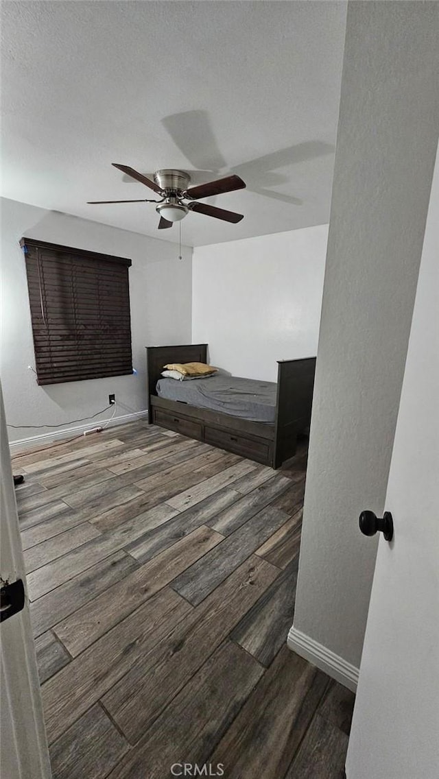 bedroom with ceiling fan, hardwood / wood-style floors, and a textured ceiling