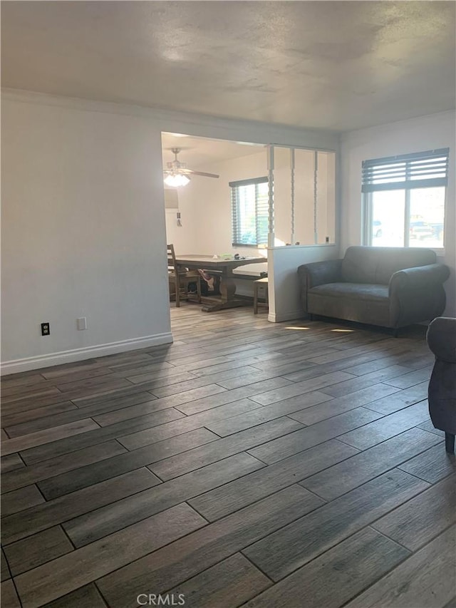 unfurnished living room with dark hardwood / wood-style flooring and ceiling fan