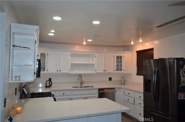 kitchen with white cabinetry, appliances with stainless steel finishes, kitchen peninsula, and sink