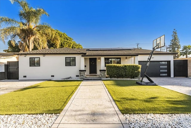 view of front of property with a garage, a front yard, and solar panels