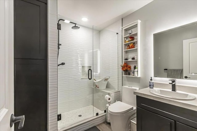 bathroom with toilet, vanity, and walk in shower