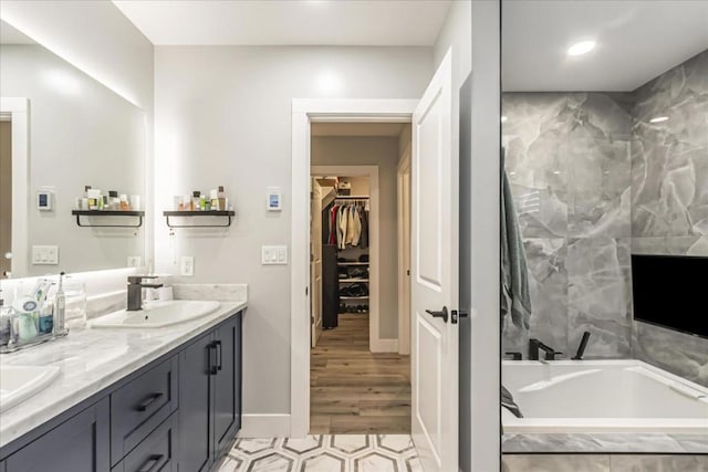 bathroom with a tub to relax in and vanity