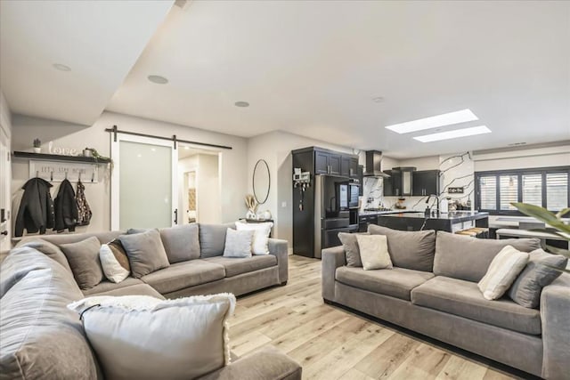 living room featuring a barn door and light hardwood / wood-style floors