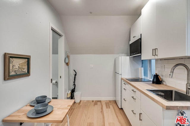 kitchen featuring sink, backsplash, white cabinetry, and light hardwood / wood-style flooring