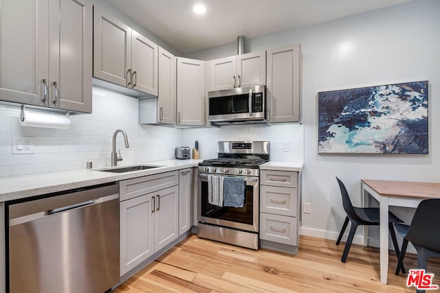 kitchen with sink, stainless steel appliances, and gray cabinets