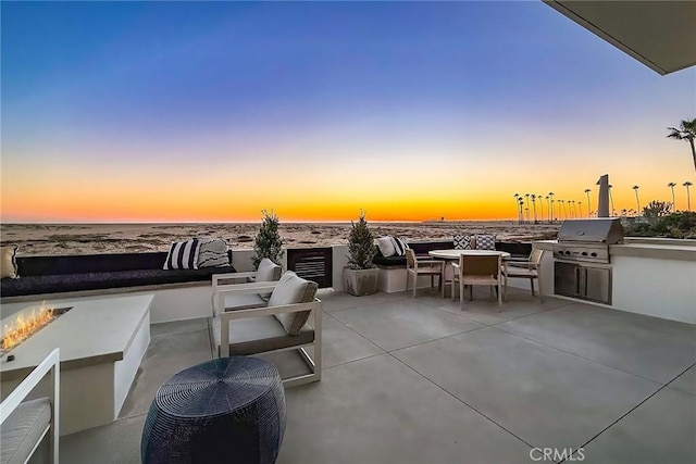 patio terrace at dusk featuring area for grilling