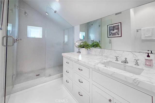 bathroom featuring vanity, tile patterned floors, walk in shower, and lofted ceiling